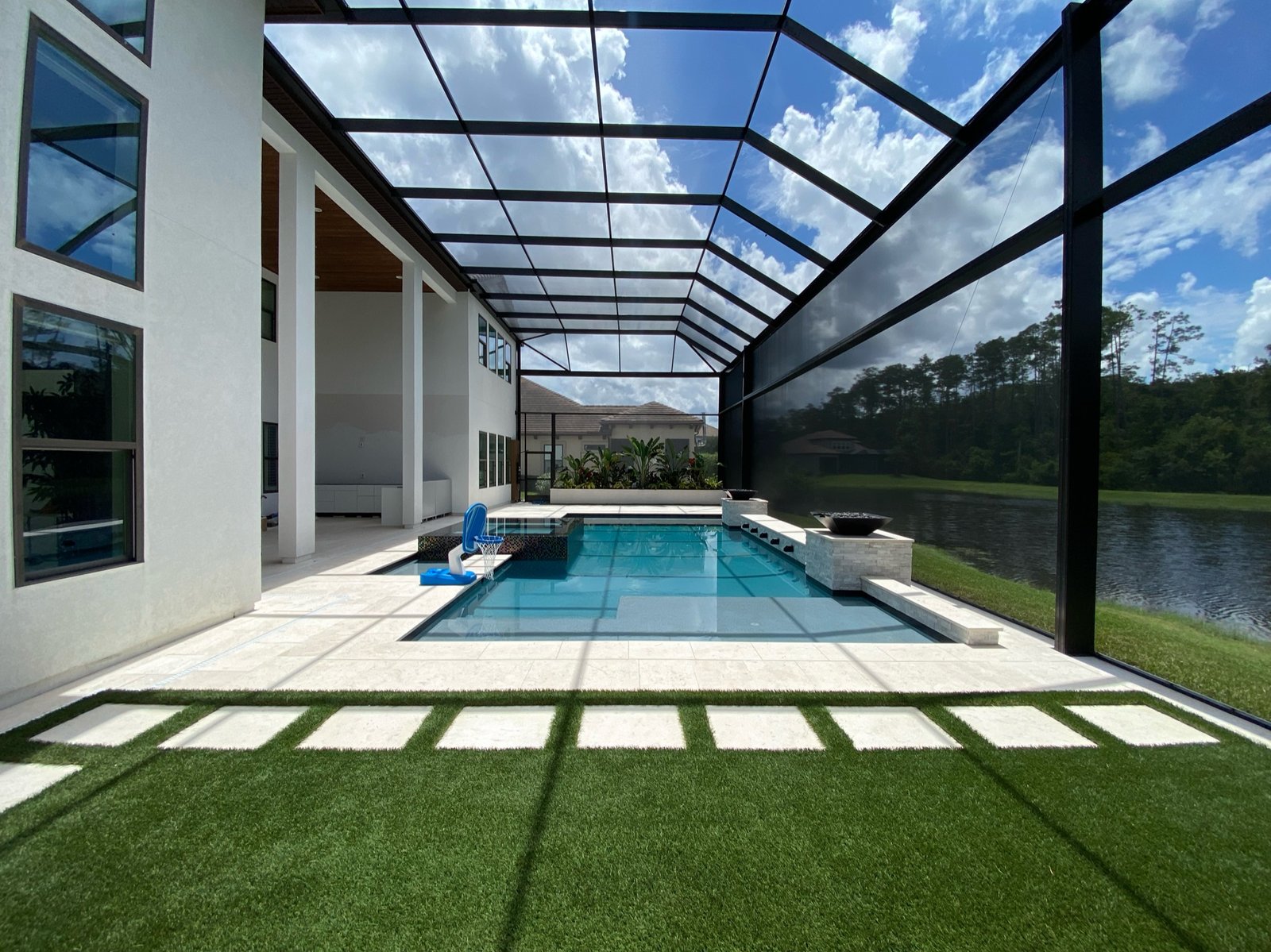 Modern pool screen enclosure installation in Winter Haven, FL overlooking lakeside backyard